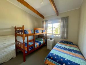 a bedroom with two bunk beds and a window at Summer Beach House in Kioloa