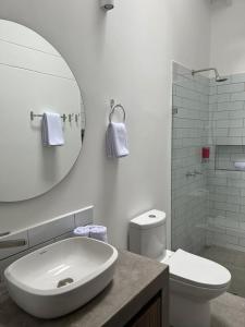 ein Badezimmer mit einem Waschbecken, einem WC und einem Spiegel in der Unterkunft El Diamante Campestre in Medellín