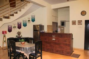a kitchen and dining room with a table and a refrigerator at Karjat Villa (3 BHK) With Garden Amidst Nature in Karjat