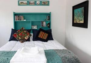 a bedroom with a bed with a green headboard and pillows at Las Glicinas de Chacras in Chacras de Coria +10 photos