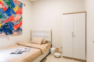 TjilandakにあるSangci-3 Bdr house near ICE BSDのベッドルーム1室(ベッド1台付)が備わります。壁には絵画が飾られています。
