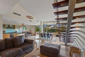 a living room with a couch and a dining room at Jades on Lawson 2 in Byron Bay