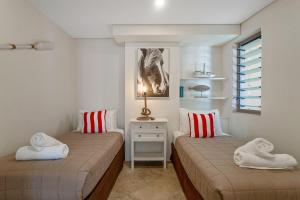 um quarto com 2 camas e toalhas em Jades on Lawson 2 em Byron Bay