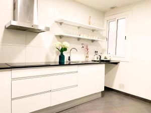 una cocina blanca con armarios blancos y fregadero en Cathedral Barcelona Rooms en Barcelona