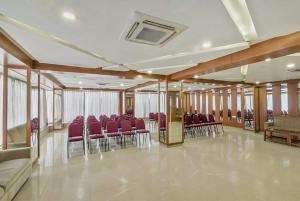 een vergaderzaal met rode stoelen en tafels erin bij Pphliving Fortune suites in Bangalore