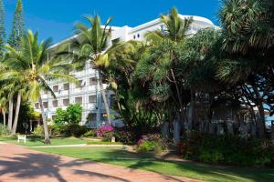 un edificio con palmeras delante en Le Méridien Nouméa Resort & Spa, en Noumea