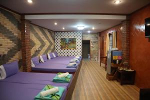una habitación con una fila de camas. en Phumthada Rommanee Krabi Resort, en Ban Khlong Khanan