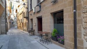 a street with chairs and a table on the side of a building at Hostal Rural Villa Vieja in Olite