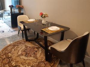 uma mesa de jantar com cadeiras e um vaso de flores em KLCC Platinum 2 by Hibernate em Kuala Lumpur