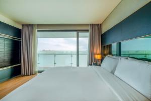 a large white bed in a room with a large window at Hotel Marinabay Seoul in Gimpo