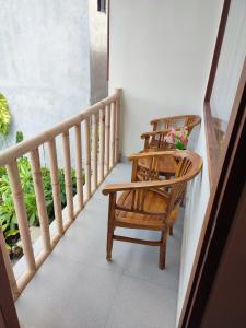 dwa krzesła i stół na balkonie w obiekcie Kubu Di-Kayla's w mieście Sanur