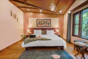 1 dormitorio con 1 cama con ordenador portátil en SaffronStays Zephyr en Nainital