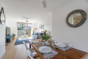 a dining room with a table with chairs and a mirror at Kiama Breeze in Kiama