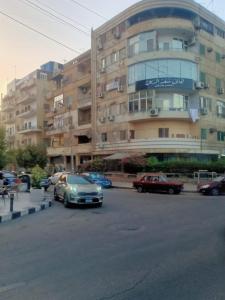 ein Parkplatz mit Autos vor einem Gebäude in der Unterkunft Baronz Car in Kairo