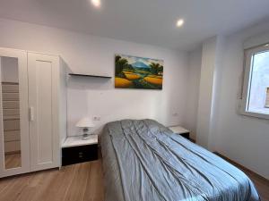 ein Schlafzimmer mit einem Bett und einem Wandgemälde in der Unterkunft Piso Castelló d'Empúries in Castelló d'Empúries