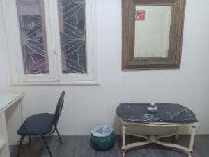 einen Tisch und einen Stuhl in einem Zimmer mit Fenster in der Unterkunft Baronz Car in Kairo