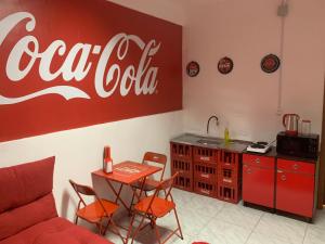 um sinal de cocacola na parede de uma sala de estar em Loft Coca-Cola Passo Fundo em Passo Fundo