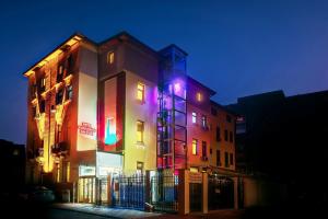 a building with colorful lights on the side of it at Hotel Amphitryon in Bucharest