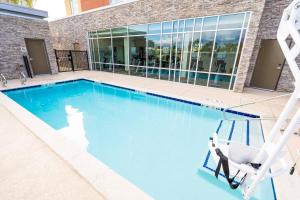 a swimming pool with a chair in front of a building at SpringHill Suites by Marriott Ontario Airport/Rancho Cucamonga in Ontario