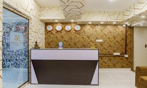 a lobby with a counter and clocks on the wall at Treebo Trend D Grand in Madurai