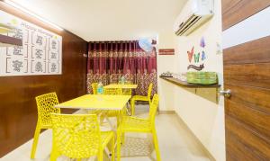 a dining room with yellow tables and yellow chairs at Treebo Trend D Grand in Madurai