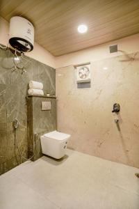 uma casa de banho com um WC e um chuveiro em SaffronStays Zephyr em Nainital