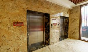 two elevators in a room with a stone wall at Treebo Trend D Grand in Madurai