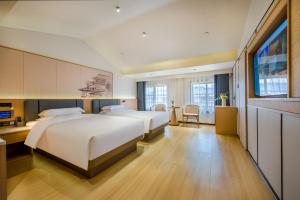Postel nebo postele na pokoji v ubytování Yiwu Baide Theme Hotel + 37 fotografií