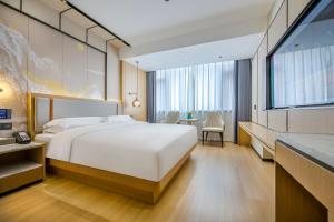 Postel nebo postele na pokoji v ubytování Yiwu Baide Theme Hotel