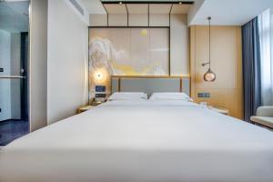 Postel nebo postele na pokoji v ubytování Yiwu Baide Theme Hotel