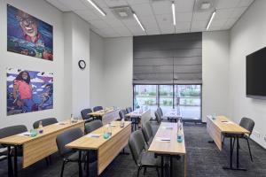 a conference room with wooden tables and chairs and a flat screen tv at Comfort Hotel LT - Rock 'n' Roll Vilnius in Vilnius