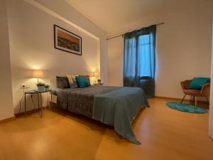 Cathedral Barcelona Rooms في برشلونة: غرفة نوم بسرير وستارة زرقاء