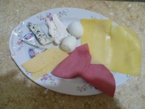 a plate with cheese and other foods on it at Baronz Car in Cairo