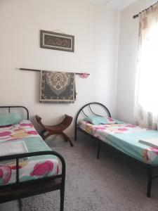 a room with two beds and a window at Roomstay homestay Ahmad Rompin in Kuala Rompin