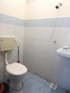 y baño con aseo y lavamanos. en Roomstay homestay Ahmad Rompin, en Kuala Rompin