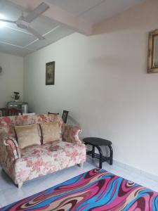 a living room with a couch and a rug at Roomstay homestay Ahmad Rompin in Kuala Rompin