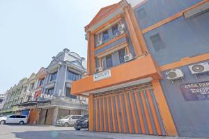 um edifício com uma porta laranja do lado de uma rua em SPOT ON 92980 Luxury Capsule Homestay em Sidoarjo