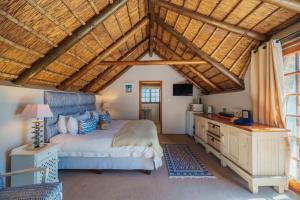 una camera con un grande letto e un soffitto in legno di Cottage on College a St Francis Bay