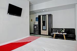 卡拉旺的住宿－Collection O 92959 Apartement Sentraland Karawang By AT Room，客房设有1张床、1台电视和1张桌子。