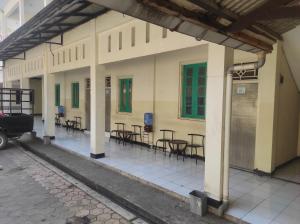 a building with tables and chairs on a street at OYO 93048 Hotel Puri Mandiri in Purworejo
