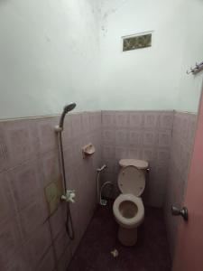 a bathroom with a toilet and a shower at OYO 93048 Hotel Puri Mandiri in Purworejo