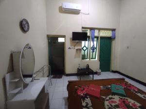 a living room with a mirror and a sink at OYO 93048 Hotel Puri Mandiri in Purworejo