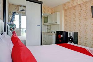 a bedroom with a large white bed with red pillows at Collection O 92967 Apartement Sentraland Karawang By Rda Living in Jaken 1