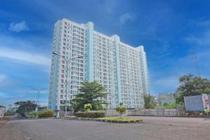 a large white building with a tree in front of it at Collection O 92967 Apartement Sentraland Karawang By Rda Living in Jaken 1