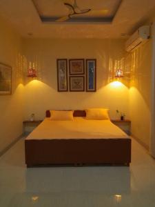 um quarto com uma cama e duas luzes na parede em Elite Room - A Home Away em Jaipur