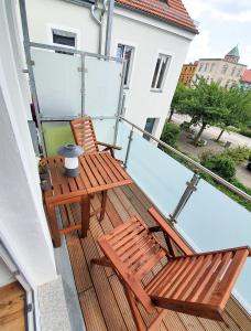 een balkon met 2 houten stoelen in een gebouw bij PB Ferienwohnungen - FeWo 4 - Stilvoll eingerichtetes Studio im Herzen Senftenbergs in Senftenberg