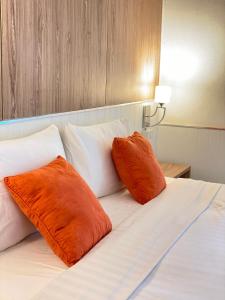 two orange pillows sitting on top of a bed at Laemsing Natural Beach Resort in Ban Pak Nam