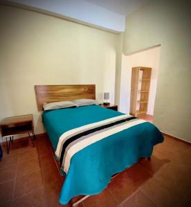 Schlafzimmer mit einem großen Bett mit einem Kopfteil aus Holz in der Unterkunft Casa Tastuán in Tonalá