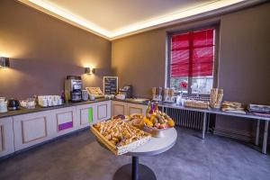 a kitchen with a table with a bowl of fruit at Hôtel De La Paix in Gérardmer
