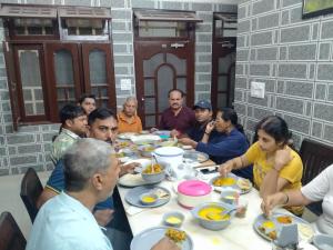 a group of people sitting around a table eating food at Mountain View in Chamba